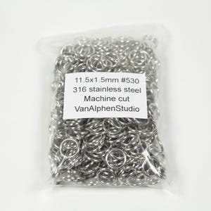 Może przedstawiać: Przezroczysty plastikowy woreczek wypełniony srebrnymi kółkami do łączenia. Woreczek ma białą etykietę z tekstem "11.5x1.5mm #530 316 stal nierdzewna Cięcie maszynowe VanAlphenStudio".