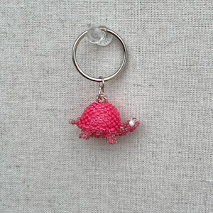 May include: A pink beaded turtle keychain with a silver key ring.