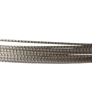 Peut inclure: Gros plan d'une bobine de fil argenté avec une surface texturée.