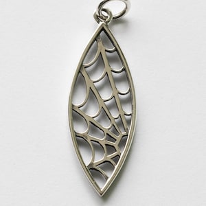 May include: A silver pendant shaped like a leaf with a detailed cutout design resembling a spider web.