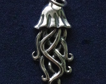 May include: A silver charm in the shape of a jellyfish with a detailed, intricate design. The charm has a bell-shaped top and long, flowing tentacles.