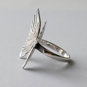 Peut inclure: Bague en argent avec un motif d'aile d&eacute;taill&eacute;. La bague est marqu&eacute;e "925" sur la bande.
