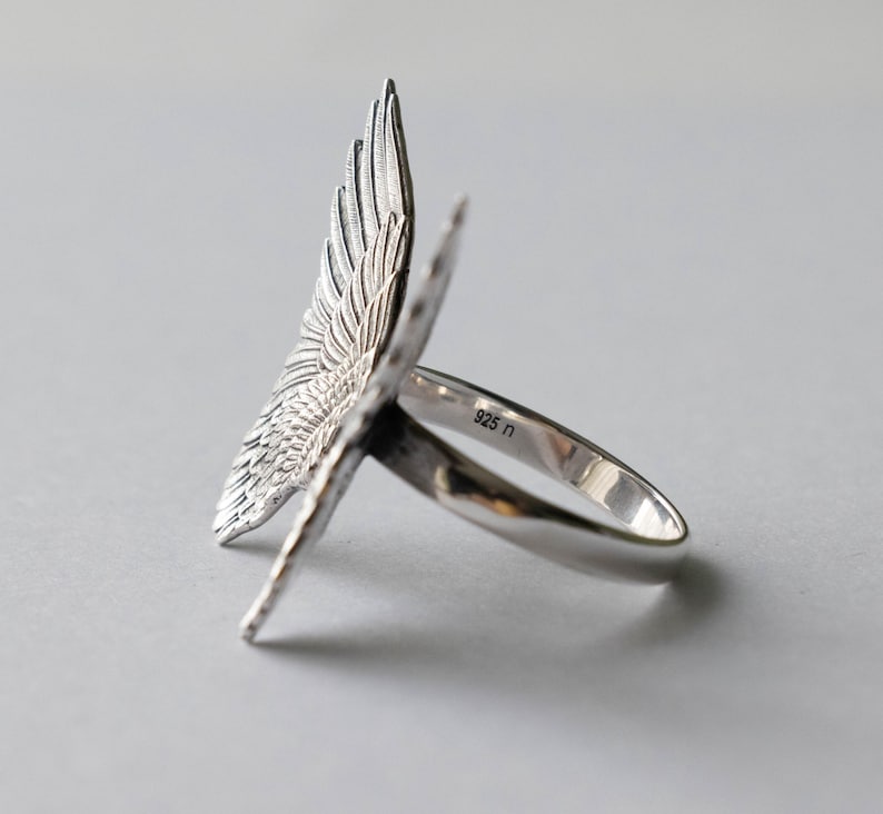 Peut inclure: Bague en argent avec un motif d'aile d&eacute;taill&eacute;. La bague est marqu&eacute;e "925" sur la bande.