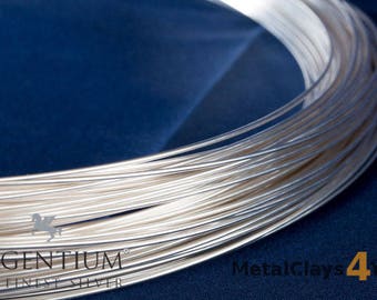 May include: A close-up of a spool of silver wire. The wire is wound tightly together, creating a smooth, shiny surface. The text "ARGENTIUM® THE FINEST SILVER" is visible on the spool.