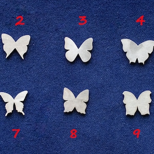 May include: Ten white paper butterfly cut-outs arranged in two rows of five on a blue background. Each butterfly is numbered 1 through 10.