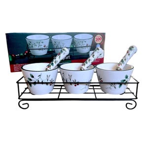 May include: Set of four white ceramic bowls with a holly and berry design, on a black metal stand with three spoons. The box says "200 Years of Excellence."