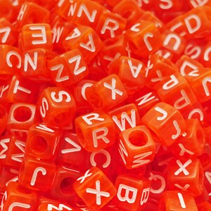 Può includere: Primo piano di un mucchio di perline di plastica rosse a forma di lettere. Le lettere sono in ordine casuale e includono le lettere A, B, C, D, E, F, G, H, I, J, K, L, M, N, O, P, Q, R, S, T, U, V, W, X, Y e Z.
