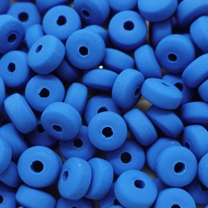 Op de afbeelding: Een close-up van een stapel felblauwe ronde kralen met een gat in het midden. De kralen zijn gemaakt van een glad, mat materiaal.