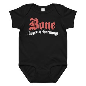 May include: Black baby bodysuit with the words "Bone thugs-n-harmony" in red and white gothic lettering. The bodysuit is a one-piece garment with short sleeves and a round neckline.