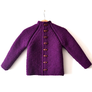 May include: A purple knitted cardigan with wooden buttons.