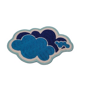 May include: Embroidered cloud patch featuring shades of blue and white. The patch has a light blue outline, a white border, and a dark blue cloud shape. The main cloud is a lighter shade of blue. This patch is suitable for jackets, bags, or other fabric items.