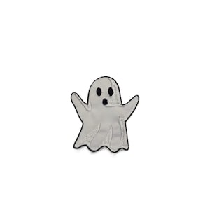 May include: An embroidered iron-on patch featuring a white ghost character with a black stitched outline. The ghost has two oval black eyes and a small circular black mouth, with arms raised in a classic spooky pose and a wavy bottom edge.