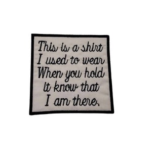 May include: White embroidered patch with black text that reads "This is a shirt I used to wear When you hold it know that I am there."