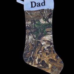 May include: A camouflage Christmas stocking with a white cuff and the word "Dad" embroidered on it.