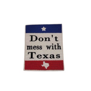 Peut inclure: Un patch brodé blanc avec un motif de drapeau américain rouge, blanc et bleu. Le patch dit "Don't mess with Texas" et présente une étoile blanche et un contour blanc de l'état du Texas.