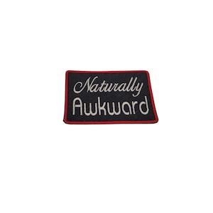 May include: Black and red embroidered patch with white text that reads "Naturally Awkward".