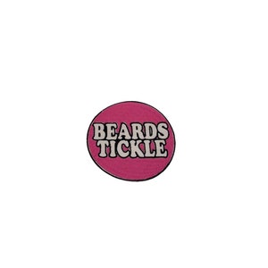 Könnte beinhalten: Ein rosa Kreis mit dem Text "BEARDS TICKLE" in Weiß.