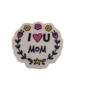 May include: White embroidered patch with a floral border. The patch says "I love you Mom" with a pink heart.