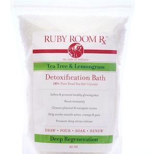 May include: A white pouch with a red and green label that reads "RUBY ROOM R™ the style of wellness. Tea Tree & Lemongrass Detoxification Bath 100% Pure Dead Sea Salt Crystals Soften & promote healthy glowing skin Boost immunity Cleanse physical & energetic toxins Help soothe muscle aches, cramps & pain Promote deep stress release DRAW POUR SOAK RENEW Deep Regeneration 42 OZ"