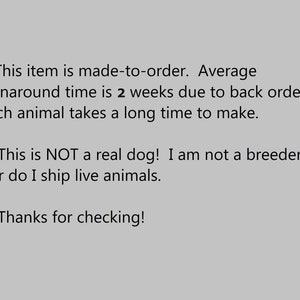 May include: Text on a gray background with a red heart symbol before each line. The text reads: "This item is made-to-order. Average turnaround time is 2 weeks due to back orders. Each animal takes a long time to make. This is NOT a real dog! I am not a breeder nor do I ship live animals. Thanks for checking!"