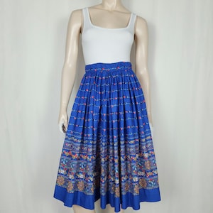 May include: A blue midi skirt with a floral print. The skirt has a gathered waist and a full skirt.