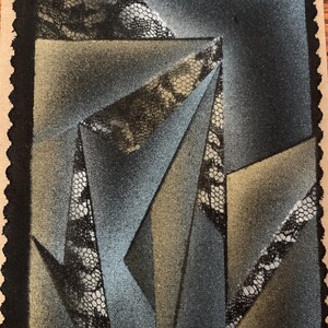 May include: Abstract geometric artwork featuring overlapping shapes in shades of gray, blue, and tan. The design incorporates lace-like patterns within the shapes, set against a textured background. The artwork is framed with a black border.
