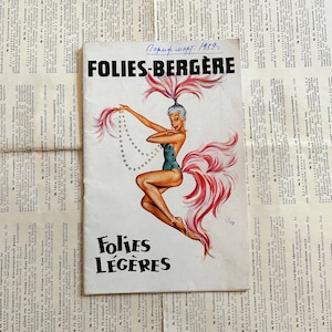 Puede incluir: Un programa vintage para el Folies-Bergère, un famoso cabaret parisino, con una ilustración colorida de una bailarina con un tocado de plumas rosas y un traje azul con lentejuelas. El programa está fechado en marzo de 1959 e incluye el título "Folies-Bergère" y "Folies Légères".