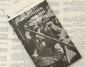 May include: A black and white photo of a guidebook for the Auschwitz-Birkenau State Museum. The cover of the book features a photo of a barbed wire fence and a guard tower. The title of the book is "OSWENCIM 1940-1945 PUTEWODITEL PO MUZEO" which translates to "Auschwitz 1940-1945 Guide to the Museum."