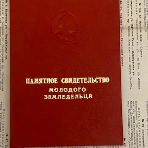 May include: A red document with a gold seal and the text "ПАМЯТНОЕ СВИДЕТЕЛЬСТВО МОЛОДОГО ЗЕМЛЕДЕЛЬЦА" in Cyrillic script.