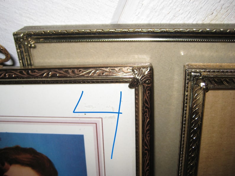 Puede incluir: Primer plano de marcos de fotos antiguos con detalles dorados ornamentados. Los marcos est&aacute;n dispuestos en una configuraci&oacute;n de m&uacute;ltiples marcos, mostrando una est&eacute;tica vintage. Los marcos tienen un paspart&uacute; beige y un fondo blanco.