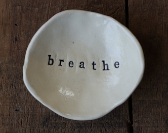 Small meditative dish imprinted with the word "breathe" composed of white stoneware, handmade.