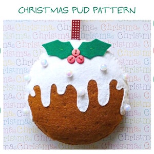 May include: A felt Christmas pudding ornament with white icing, red and green holly, and white pearl beads. The ornament is hanging from a red and white ribbon.