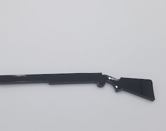 May include: A black plastic silhouette of a rifle, a common toy for children.