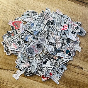K&ouml;nnte beinhalten: Eine gro&szlig;e Sammlung von Buch-Stickern in Schwarzwei&szlig; mit einigen roten Akzenten. Die Sticker zeigen verschiedene Buch-bezogene Zitate und Illustrationen, darunter einen Sch&auml;del, einen B&uuml;cherwurm und ein Herz.