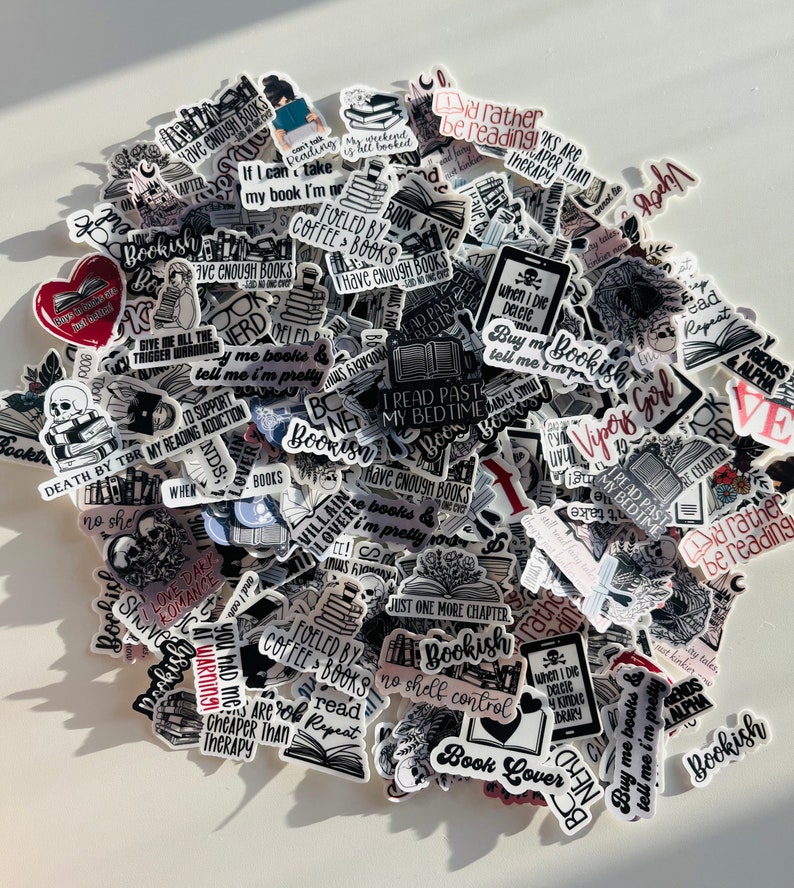K&ouml;nnte beinhalten: Eine Sammlung von schwarz-wei&szlig;en Aufklebern mit roten und rosa Akzenten, die Buch-bezogene Zitate und Illustrationen zeigen. Die Aufkleber enthalten S&auml;tze wie "Ich w&uuml;rde lieber lesen", "Ich habe genug B&uuml;cher", "Bookish" und "Tod durch TBR".