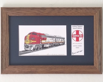 May include: A framed print of a red, white, and yellow Santa Fe train with the text "Santa Fe" and "Motive Power Series" on a white background. The print is signed by Michael Albert West.