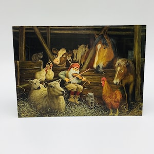 May include: A Christmas card featuring a whimsical barn scene. A gnome plays a violin surrounded by farm animals, including horses, cows, sheep, chickens, and a rooster. The artwork has a rustic, detailed style with warm colors.