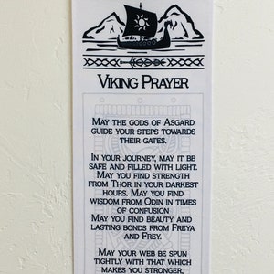 May include: White Viking Prayer banner with black graphic of a Viking ship, mountains, and decorative borders. The text reads "Viking Prayer" and includes a prayer for guidance, strength, and wisdom.