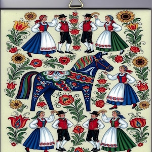 May include: A decorative tile featuring a blue Dala horse surrounded by dancers in traditional folk costumes. The dancers are in red, white, and blue outfits, with floral accents. The background is a cream color.