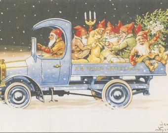 Puede incluir: Ilustración vintage de un camión azul que transporta gnomos y un perro en una escena nevada. Los gnomos llevan gorros rojos y están acompañados por un candelabro y un pequeño árbol de Navidad. El camión tiene el texto "A.B. Nisse Nasse & Co."