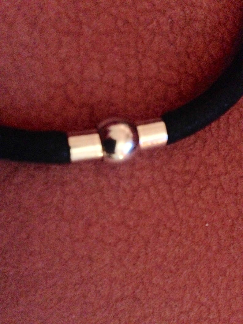 May include: A black elastic bracelet with a silver ball clasp.