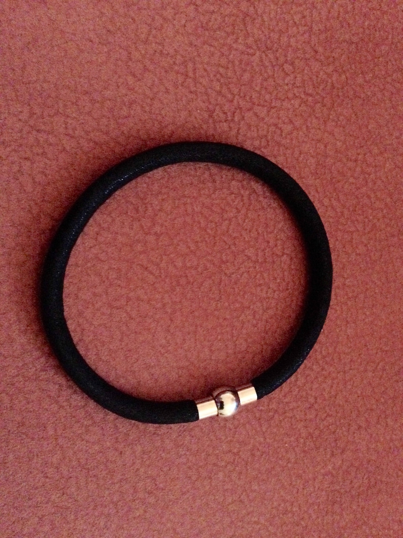 May include: A black elastic bracelet with a silver magnetic clasp.