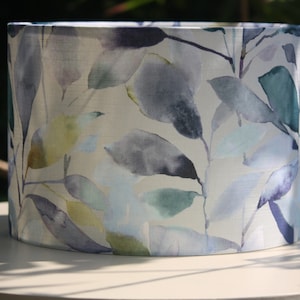May include: A white lampshade with a watercolour pattern of blue, green, and purple leaves.
