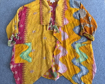 Peut inclure: Veste patchwork aux tons jaune, rose et orange. La veste présente un col châle, des poches et un design asymétrique unique. Le tissu a un aspect texturé avec des coutures décoratives, créant une esthétique bohème.