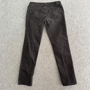 Pu&ograve; includere: Jeans in denim grigio scuro con un classico design a cinque tasche. I jeans presentano cuciture decorative sulle tasche posteriori e una piccola toppa con logo in vita. I jeans sono a gamba dritta.
