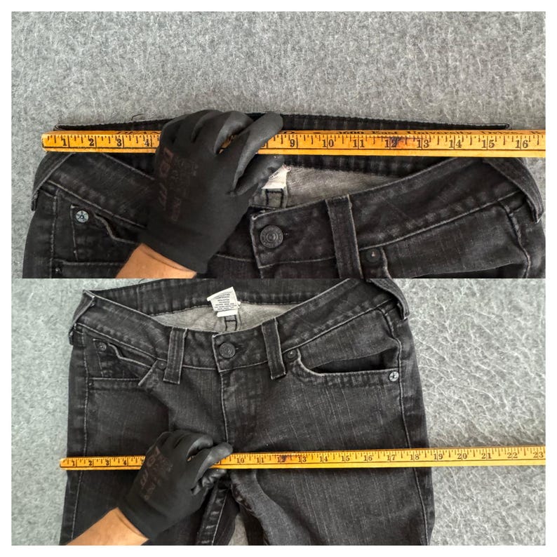 Pu&ograve; includere: Jeans in denim nero con chiusura a bottone, passanti e tasche. Un righello mostra che la misura della vita &egrave; di circa 40,6 cm. I jeans sono appoggiati su una superficie grigia.