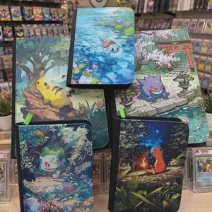 May include: A collection of five rectangular trading card binders featuring colorful illustrations of Pikachu, Squirtle, Gengar, Bulbasaur, and Charmander in various natural settings. Each binder has a black border and a green zipper pull tab.