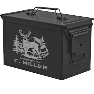 May include: Black metal ammo can with a deer silhouette and trees graphic. The text "PROPERTY OF C. MILLER" is printed on the front.