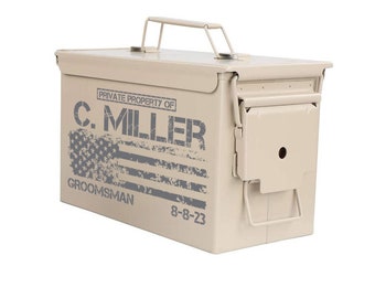 May include: A tan metal ammo can with a handle. The can has a distressed American flag design and the text "PRIVATE PROPERTY OF C. MILLER GROOMSMAN 8-8-23".