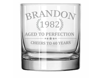 May include: A clear glass tumbler with the text "BRANDON 1982 AGED TO PERFECTION CHEERS TO 40 YEARS" etched on the side.